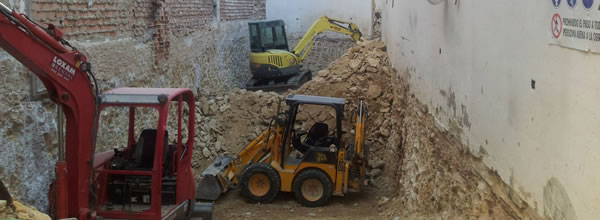 Tres máquinas excavadoras trabajando en un espacio reducido